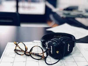 Glasses and headphones on a desk calendar, highlighting a modern workspace setup.